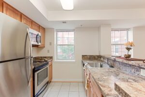 kitchen with stainless steel appliances, microwave, breakfast bar and window at the oaks apartments in washington dc