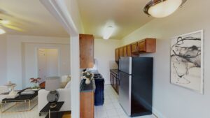 view of kitchen with fridge, gas range and view of living area at the klingle apartments in cleveland park washington dc