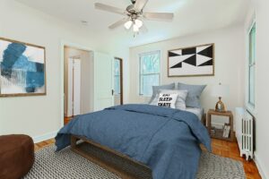 bedroom with bed, night stand, ceiling fan and hardwood floors at 1400 van buren apartments in washington dc