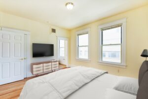 bedroom with large windows, wood floors and view of bathroom at twin oaks apartments in petworth washington dc