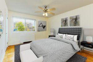 bedroom with bed, nightstands, ceiling fan, and large windows at chillum place apartments in washington dc