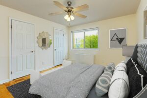 bedroom with bed, hardwood floors, ceiling fan and large windows at chillum place apartments in washington dc