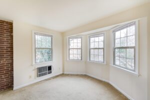vacant sun room with exposed brick wall and large windows at 2629 39th Street apartments in washington dc