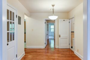 hallway view of front entrance, bathroom and living area with wood floors and lighting at 2629 39th Street apartments in washington dc