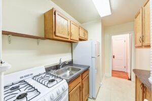 kitchen with fridge, gas range, and wood cabinets at 2629 39th Street apartments in washington dc