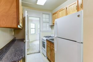 kitchen with refrigerator, gas range and breakfast bar at 2629 39th Street apartments in washington dc