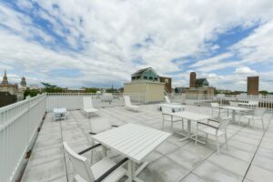 rooftop lounge with social seating, tables and view of washington dc at hilltop house apartments in columbia heights washington dc