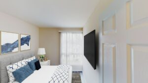 bedroom with bed, nightstand, tv and windows at city towns apartments in washington dc