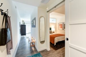 bedroom entry with mirror, barn door and view of living area at the garrett apartments at the collective in washington dc