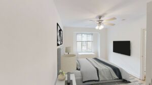 bedroom with bed, nightstand, large window and ceiling fan at 2800 woodley road apartments in washington dc
