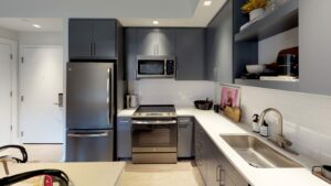 kitchen with stainless steel appliances, gooseneck faucet, tile backsplash and kitchen island at avec on h luxury apartments in washington dc