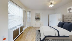bedroom with bed, dresser, hardwood floors, large windows and ceiling fan at the calverton apartments in adams morgan washington dc