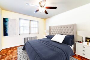 bedroom with wood floors, ceiling fan and radiator at richman apartments in congress heights washington dc