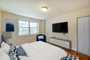 bedroom with bed, sitting area, windows and closet at shipley park apartments in washington dc