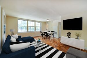 living area with sofa, coffee table, large windows and view of dining area at shipley park apartments in washington dc