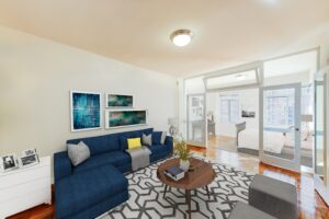 living area with sofa, coffee table, and view of sunroom with french doors and large windows at the baystate apartments in dupont circle washington dc