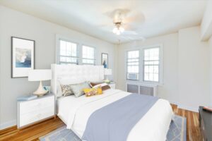 bedroom with bed, nightstands, large windows, ceiling fan and hardwood floors at the frontenac apartments in van ness washington dc
