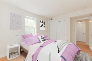 bedroom with bed, nightstands, wood floors, closet and window at the oaks apartments in washington dc