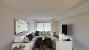 living area with sofa, coffee table, tv, credenza and large windows at washington view apartments in washington dc