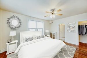 bedroom with nightstands, large closets, ceiling fan and hardwood floors at hampton courts apartments in washington dc