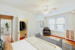 bedroom with bed, sitting area, large closet and large windows at hampton courts apartments in washington dc