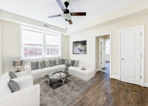 living area with sofa, coffee table, wood floors, ceiling fan and large windows at petworth station apartments in washington dc