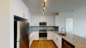 kitchen with stainless steel appliances, breakfast bar and hardwood floors at crest at skyland town center apartments in washington dc