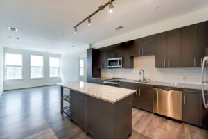 kitchen with stainless steel appliances, kitchen island and hardwood floors at crest at skyland town center apartments in washington dc