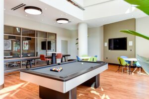 club room with social seating, conference room, shuffleboard, and pool table at crest at skyland apartments in washington dc