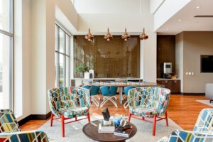 club room with social seating, communal dining table, entertainment kitchen and tvs at crest at skyland apartments in washington dc