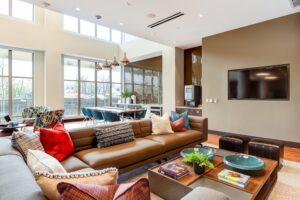 club room with social seating, tv, communal dining table and entertainment kitchen at crest at skyland apartments in washington dc