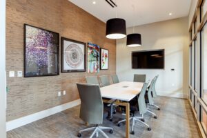 conference room with table, chairs, monitor and modern artwork at crest at skyland apartments in washington dc
