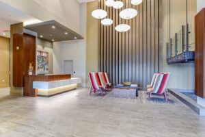 lobby lounge with social seating, modern lighting, artwork and concierge desk at crest at skyland town center apartments in washington dc
