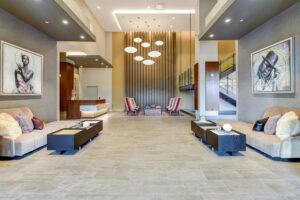lobby lounge with social seating, modern lighting, artwork and concierge desk at crest at skyland town center apartments in washington dc