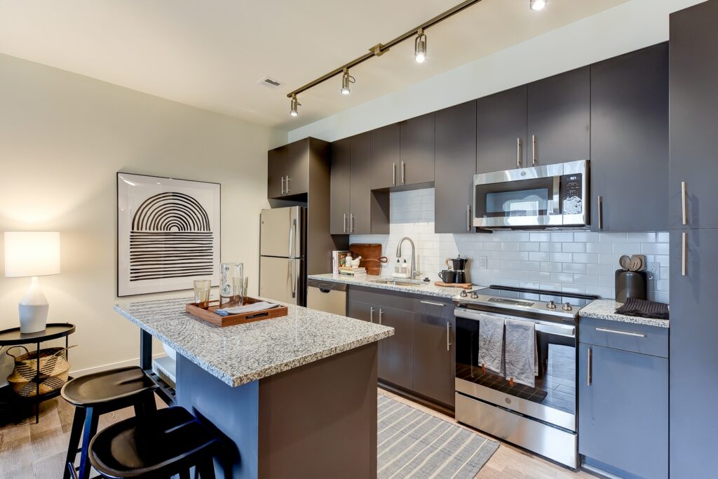 kitchen with espresso cabinetry, tile back splash, kitchen island and hardwood floors at crest at skyland town center apartments in washington dc
