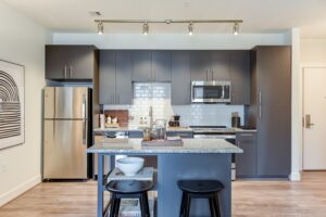 kitchen with stainless steel appliances, kitchen island and hardwood floors at crest at skyland town center apartments in washington dc