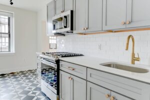 kitchen with stainless steel appliances, modern cabinetry, gooseneck faucet and tile backsplash at the dahlia apartments in washington dc