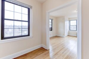 vacant apartment showing living area and bedroom with wood floors and large windows at the dahlia apartments in washington dc