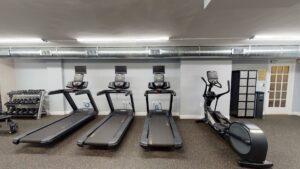 fitness center with cardio machines and free weights at 2800 woodley road apartments in washington dc
