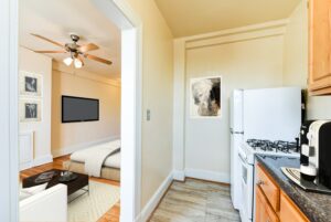 kitchen in studio apartment with refrigerator, gas range and view of living area at the foreland apartments in capitol hill washington dc