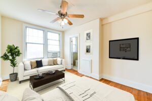 studio apartment with bed, sitting area, large windows, hardwood floors and view of bathroom at the foreland apartments in capitol hill washington dc