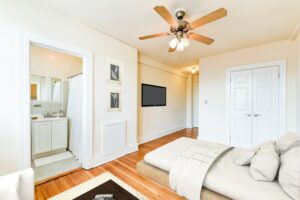studio apartment with bed, sitting area, large closet, hardwood floors and view of bathroom at the foreland apartments in capitol hill washington dc