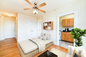 studio apartment with bed, sitting area, large windows, hardwood floors and view of kitchen at the foreland apartments in capitol hill washington dc