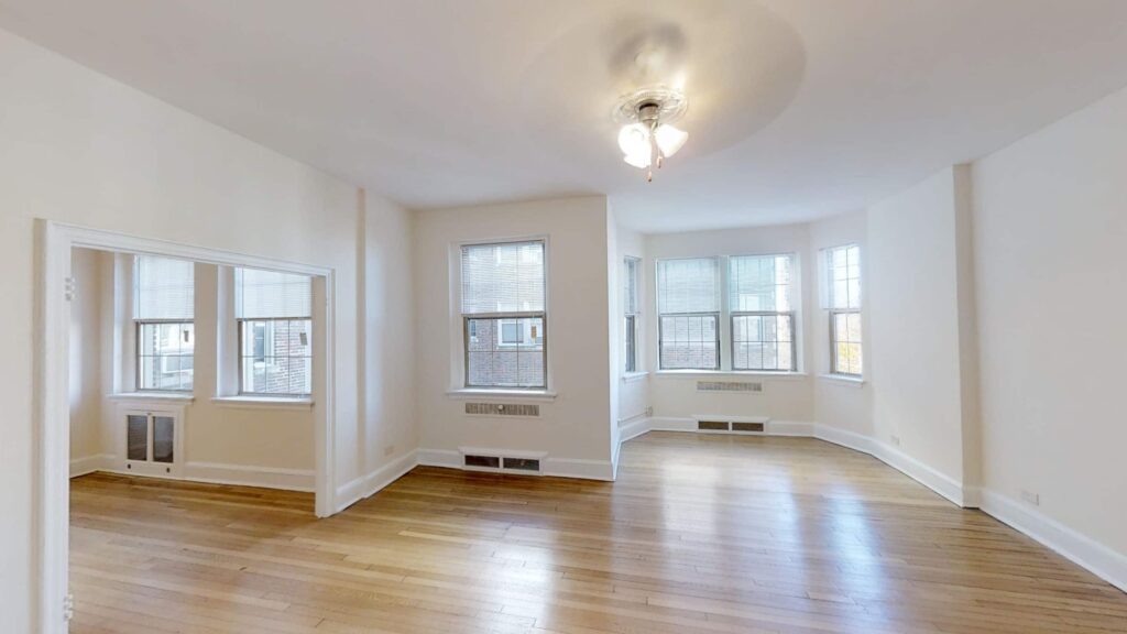 living area with hardwood floors, large windows and ceiling fan at 2800 ontario road apartments in washington dc