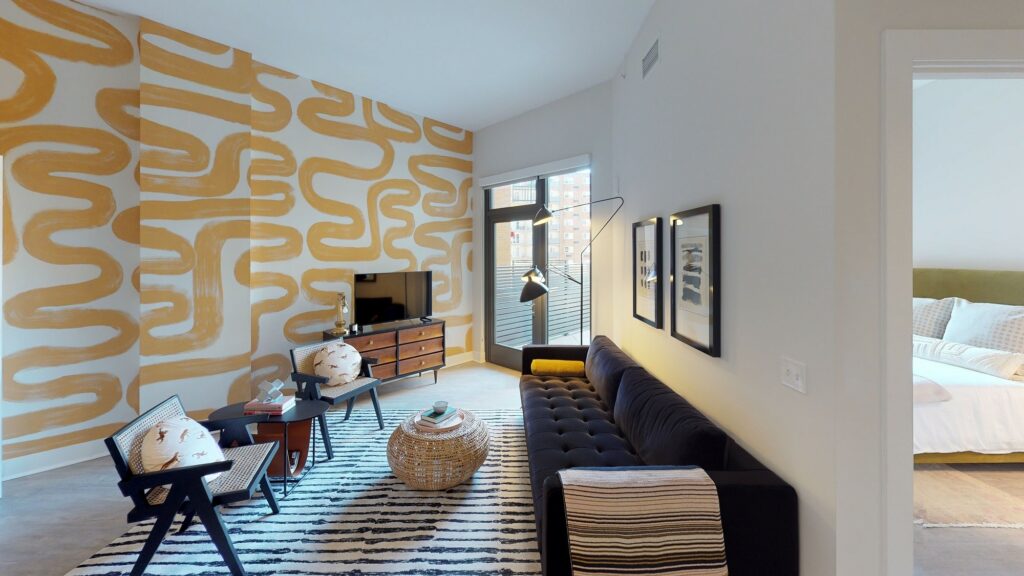 living area at avec apartments with sofa, sitting chair, balcony door and view of bedroom in washington dc