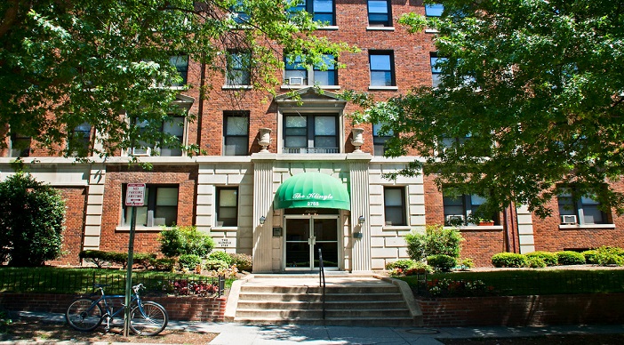 exterior view of the stone and brick apartment building and the green awning at the klingle apartments in washington dc