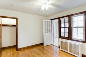 vacant bedroom with closet, wood floors, ceiling fan and view of sunroom at 2629 39th Street apartments in washington dc