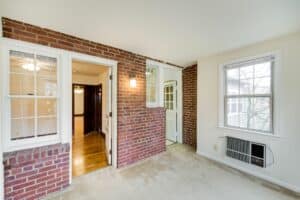 vacant sun room with exposed brick wall and large windows at 2629 39th Street apartments in washington dc