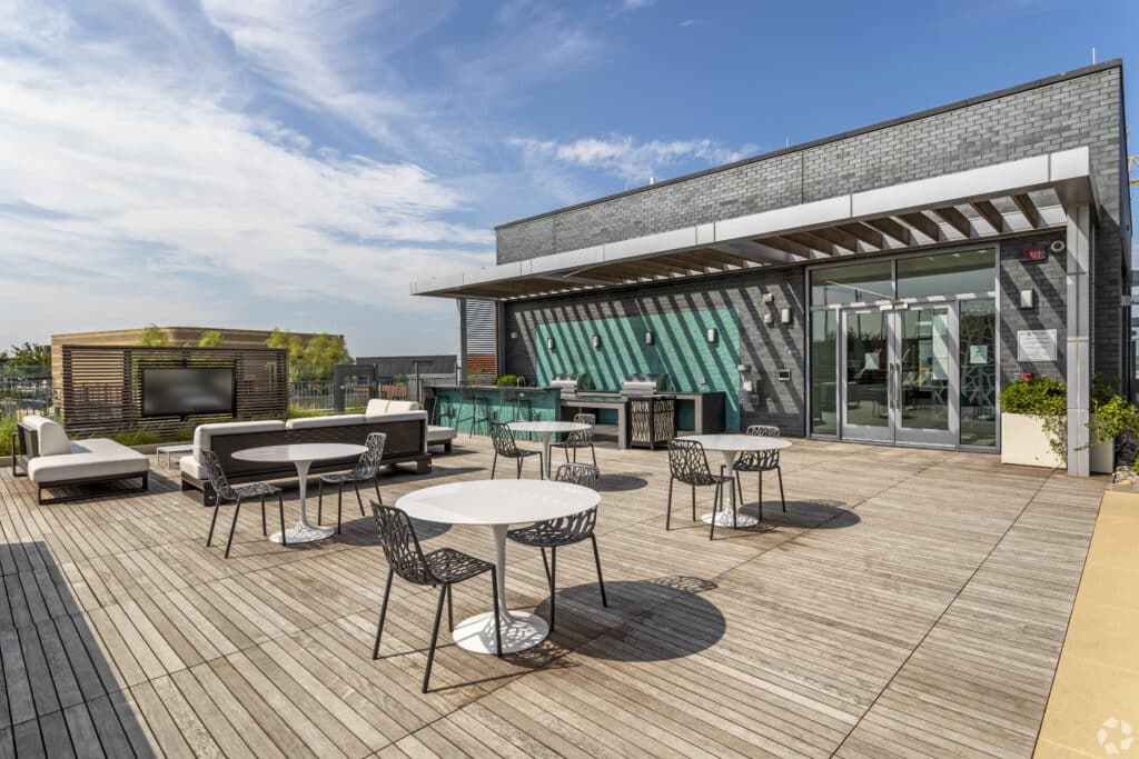 rooftop lounge with grilling stations, tv, social seating and dining tables at agora apartments in washington dc