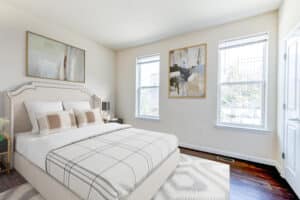 bedroom with bed, nightstands, hardwood flooring and large windows at sheridan station south townhomes apartments in washington dc